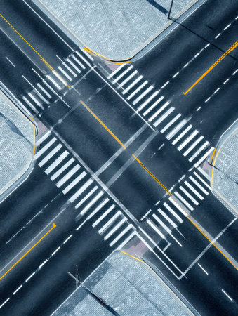 A top-down perspective captures a bustling urban crossroads, highlighted by painted crosswalks and...