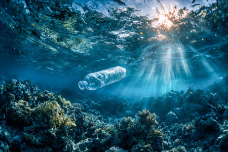 Sunrays pierce a pristine blue ocean, revealing a solitary plastic container amid colorful coral...