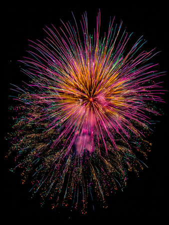 A dazzling explosion of vibrant hues paints the dark canvas overhead, casting a festive glow and capturing the awesomeness of a celebratory evening spectacle.の写真素材