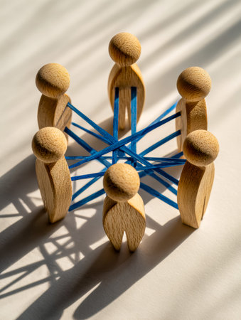 Wooden human-shaped figures linked by vibrant blue threads, illustrating a conceptual web of...