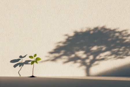 A tiny sprout pushes upward alongside a stark wall, its shadow stretching behind, symbolizing...