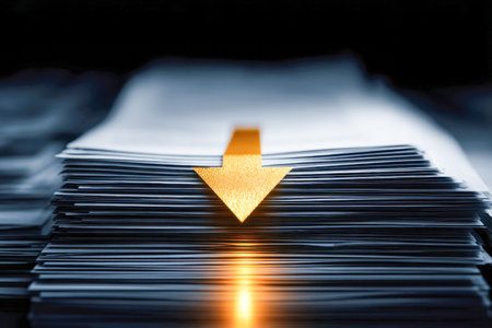 A detailed view of numerous layered papers highlighted by a luminous gold arrow pointing downward,...