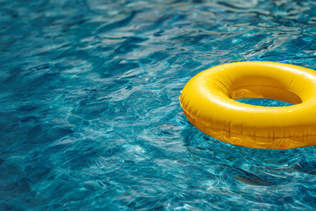 A cheerful yellow ring glides softly across a mirror-like, azure pool, shimmering under the warm...