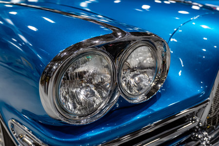 A timeless deep blue automobile showcasing dual round headlights and gleaming chrome details,...