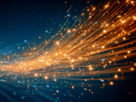 Radiant golden streaks swirl vividly across a shadowy cosmic backdrop, dotted with shimmering particles that evoke a powerful sense of movement and vibrant energy.の写真素材