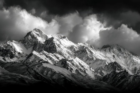 Monochrome image capturing jagged mountain summits shrouded in swirling clouds, with frosted peaks...