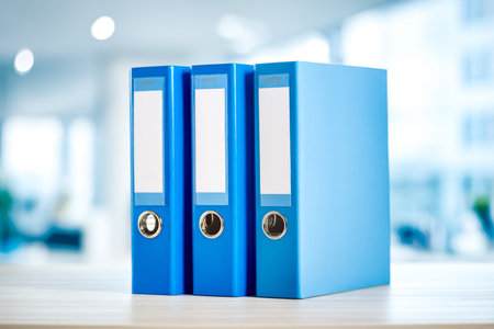 Vibrant blue binders arranged neatly on a work surface, suggesting organization and professionalism in a modern office environment.の写真素材
