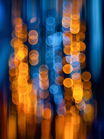 A blend of energetic orange and soothing blue light trails cascades vertically, forming a lively, dreamlike scene with luminous orbs and motion streaks.の写真素材