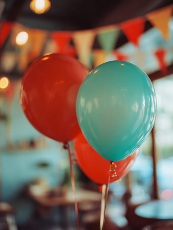 Bright red and turquoise balloons drift gently in a cozy indoor setting, complemented by lively...