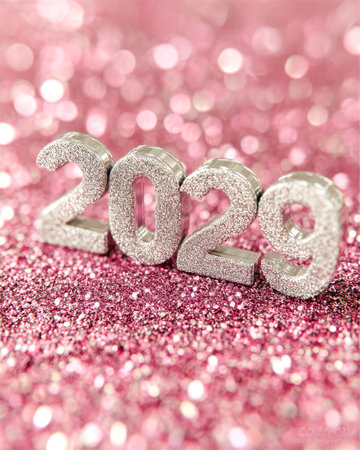 Shimmering silver numeral figures forming 2022 rest against a luminous pink backdrop adorned with...