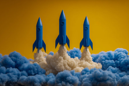 Three miniature blue rockets burst upward amid swirling blue and white vapor, set against a bold orange backdrop, evoking dynamic motion and imaginative space explorationの写真素材