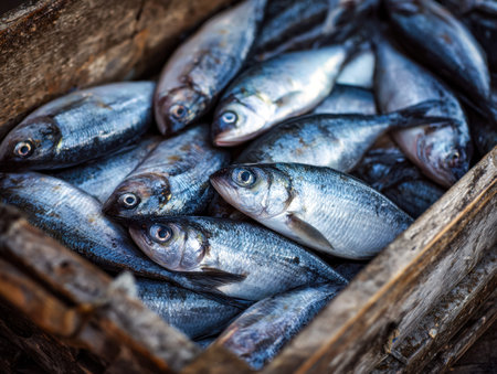 A collection of shimmering, freshly cleaned fish layered in a weathered wooden container, evoking a...