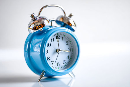 An antique-inspired blue clock with a classic ringing bell design, evoking nostalgia and charm, set...