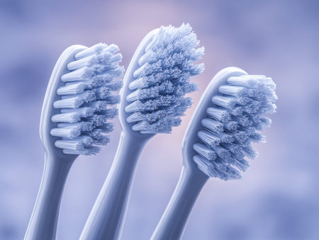 Three gentle-bristled electric toothbrush attachments are positioned neatly on a subtly blurred...