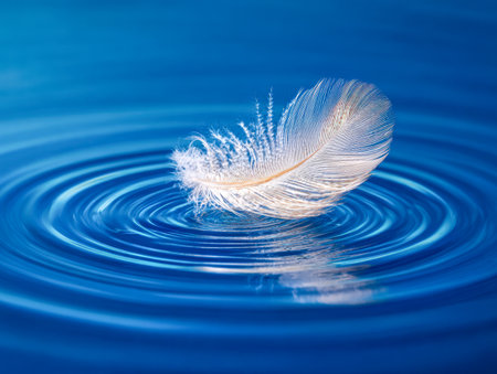 A pristine white plume drifts softly atop placid aquamarine hues, spreading gentle circles that mirror a peaceful, meditative essence in nature's calm embrace.の写真素材