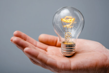 A hand gently cradles a luminous vintage bulb, its warm glow symbolizing fresh insights, inventive...