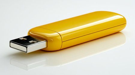 A vibrant yellow portable memory module with a metallic plug, mirrored on a glossy white surface, evoking themes of seamless data exchange and modern digital mobilitの写真素材