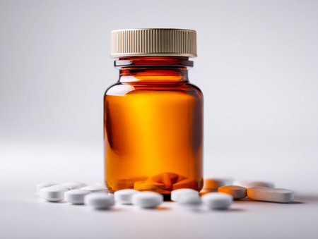 A vintage-style amber medicine container with a neutral beige lid, accented by an array of white and orange pills, evoking health, safety, and remedy themes.の写真素材