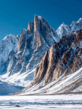 Giant icy summits pierce the sky, cloaked in snow, contrasting against a brilliant azure backdrop, amid an expansive glacial wilderness bathed in winter sunlight.の写真素材