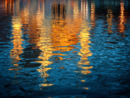 Mesmerizing interplay of luminous gold and deep cerulean hues dancing across a textured water...