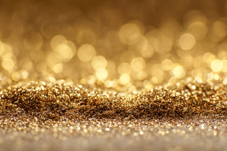 A shimmering cascade of gold glitter illuminates a surface, complemented by soft bokeh lights that evoke an elegant, celebratory ambiance perfect for festivities and luxuの写真素材