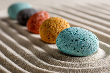 Vibrant, tactile stones form a gentle zigzag design atop smooth, meticulously raked sand, creating a serene scene that embodies harmony and peaceful simplicity.の写真素材