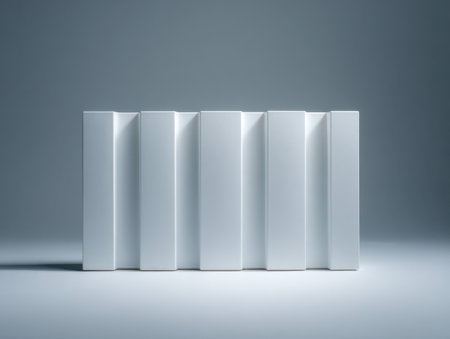 A sleek, organized lineup of blank white book spines stretches evenly across a smooth gray surface, illuminated gently to highlight their crisp simplicity.の写真素材
