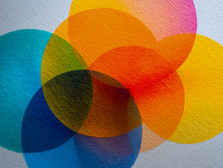 Vibrant semi-transparent circles intertwine, forming dynamic layered patterns against a textured white backdrop, inspiring creative design and artistic exploration.の写真素材