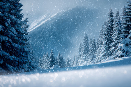 A tranquil winter scene featuring thick pine forests blanketed in snow, softly falling as misty mountains fade into a muted, cloudy sky, evoking peaceful solitude.の写真素材