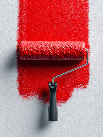 A paint roller coated in bold crimson hue presses against a coarse gray backdrop, leaving a striking textured streak ideal for creative or refurbishment ideas.の写真素材