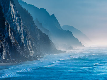 Bathed in soft morning light, rugged cliffs rise dramatically above swirling azure waters, with silhouettes of pine trees blending into a tranquil, misty sky.の写真素材