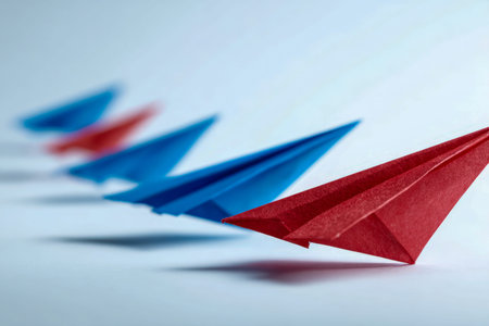 A bold red paper aircraft soars ahead of a fleet of calm blue counterparts, highlighting...