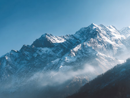 A stunning panorama of icy peaks under a pristine azure sky, softened by delicate wisps of mist, evoking tranquility and awe in untouched winter wilderness.の写真素材