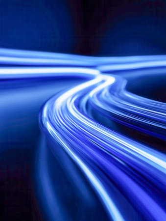 Vibrant blue streaks swirl and cascade across a dark canvas, forming an energetic abstract design that evokes motion, innovation, and advanced digital realms.の写真素材