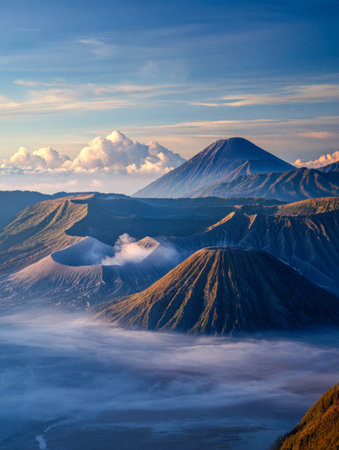 A breathtaking vista of towering volcanic peaks shrouded in soft morning fog, illuminated by a...
