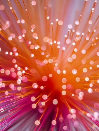A luminous explosion of orange and pink threads twirls in a mesmerizing dance, blending vivid hues with gentle blurred glows for a lively, energetic visual.の写真素材
