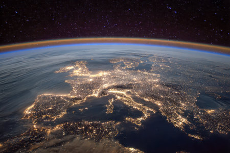 A breathtaking aerial vista capturing Europe's glowing cities and shimmering coastlines against a star-studded night sky, highlighting vibrant urban vitality from spの写真素材