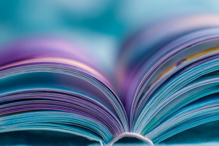 A lively burst of book pages gracefully fans outward, blending into a spectrum of vivid hues with a gentle blur and delicate focus for a dreamy, artistic feel.の写真素材