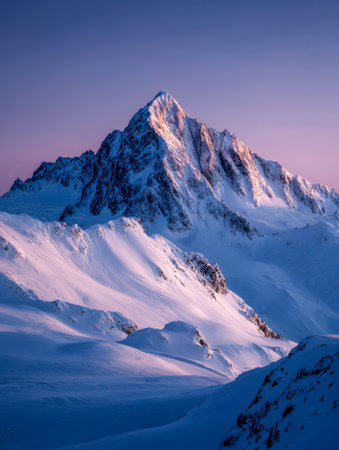 A towering, frost-kissed summit glows gently in dawn's tender light, set against a vivid violet sky for a peaceful and calming winter panorama.の写真素材