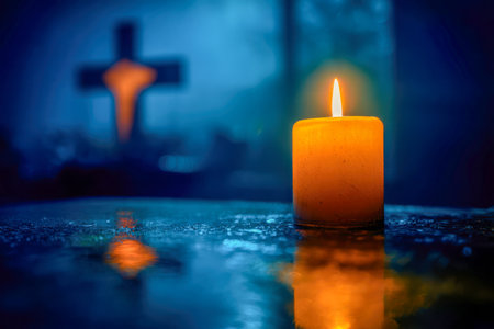 A gentle flicker of light dances on a mirrored surface, with a muted cross softly blurred behind, evoking quiet reflection during twilight's gentle hush.の写真素材