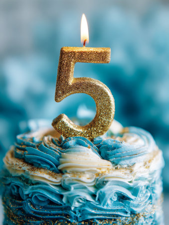 A radiant golden numeral five candles illuminates vibrant blue and white frosted cake, capturing a joyful moment of celebrating a memorable five-year journey.の写真素材