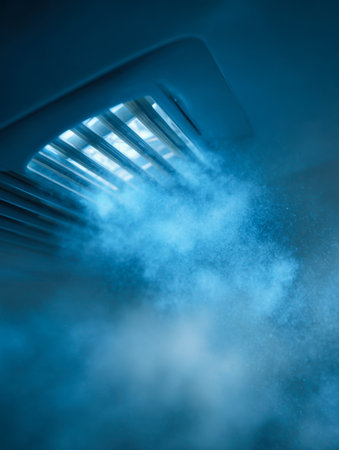 A soft blue glow bathes swirling vapor escaping from a ceiling vent, crafting an invigorating ambiance that evokes calmness and crispness within the indoor environmeの写真素材