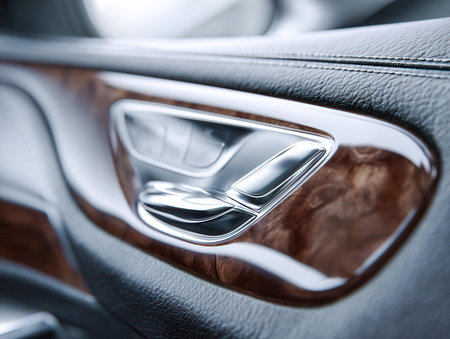 An opulent vehicle interior showcasing a gleaming silver door handle, deep-toned wood accents, and...