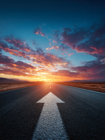 A lone highway stretches into the distance, marked by a bold arrow guiding towards a fiery sunset, evoking hope, fresh starts, and the vast potential ahead.の写真素材