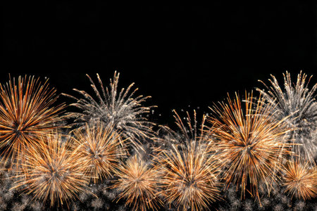 Bright bursts of shimmering gold and silver light illuminate the night, leaving sparkling trails...