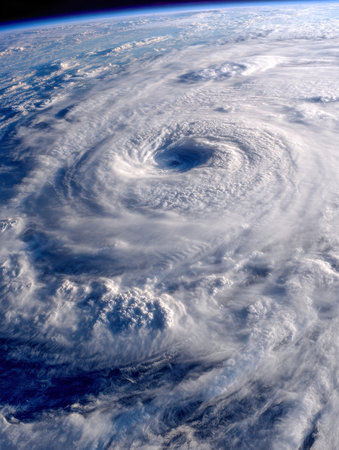 An awe-inspiring glimpse of Earth's atmosphere revealing a colossal cyclone with a defined eye and extensive swirling cloud patterns, highlighting nature's raw powerの写真素材