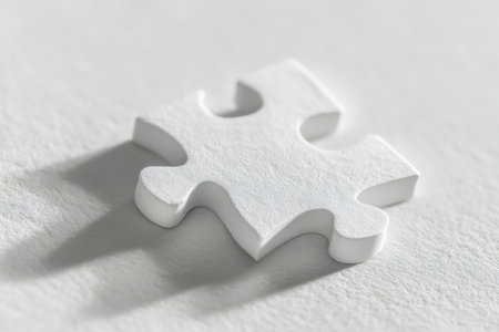 A lone white puzzle fragment extends its shadow across a tactile surface, visually representing the search for solutions and the quest to complete a bigger picture iの写真素材