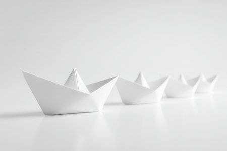 Elegant white paper crafts aligned neatly on a glossy surface, emphasizing simplicity and clarity while highlighting subtle depth through precise reflections.の写真素材