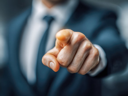 A confident executive in a tailored suit maintains eye contact and extends a decisive finger, fostering a sense of engagement and trust amidst a softly blurred backdの写真素材