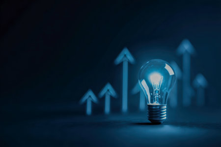 In a dark setting, a luminous filament bulb radiates brilliance, with energetic arrows ascending behind it?evoking ideas, progress, and transformative business growtの写真素材